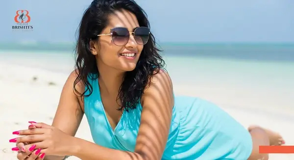 Woman relaxing on a beach with perfect nails, ready for vacation.
